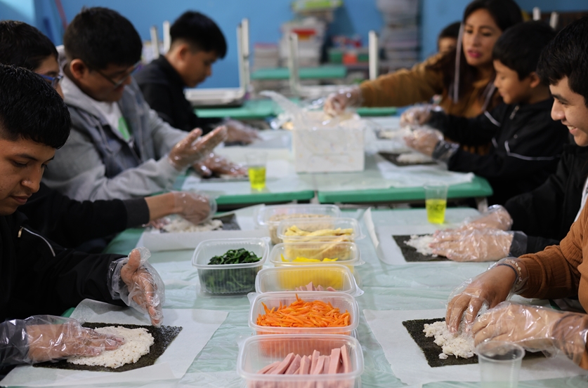 가족과 함께 한국 전통 음식인 김밥 만들기를 하고 있다